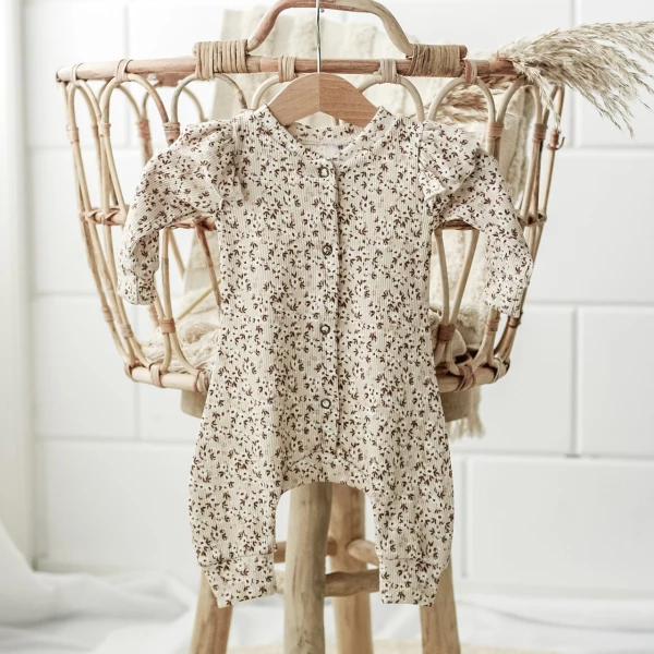 Een boxpakje met ruffles van ribstof in een bloemenprint beige.